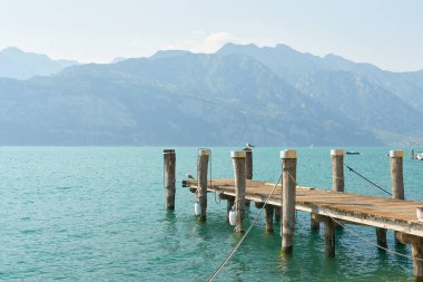 Malcesine 'deki Garda Gölü kıyısında, batı kıyısındaki Alpler manzaralı bir iskele.                               