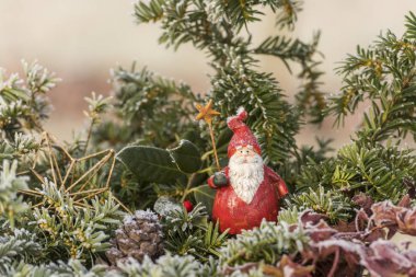 Frost çam dalları arasında oturan kırmızı Noel Noel Baba Şekil