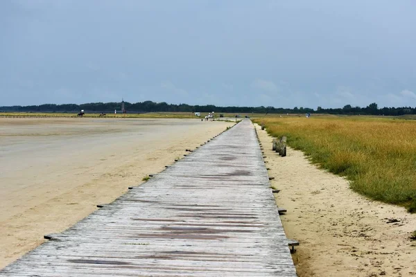 Muelle de madera en la costa alemana del Mar del Norte en la playa de arena con dique — Foto de Stock