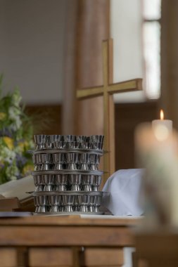 Kilise haç bir komünyon fincan ve bulanık yanan mum ile bir sunak üzerinde duruyor