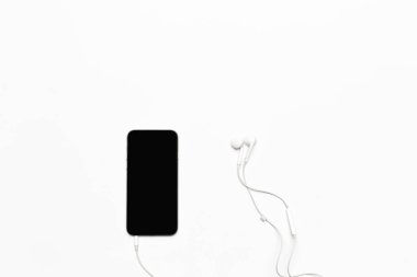 Hareket eden telefon ile beyaz kulaklık beyaz izole