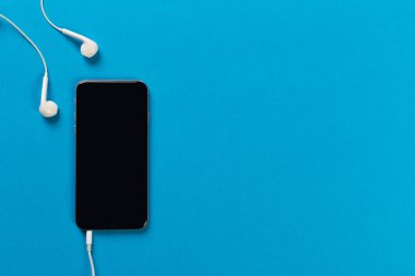 Hareket eden telefon ile renk backgroung, üstten görünüm üzerinde beyaz kulaklık