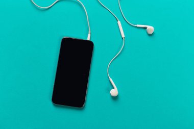 Hareket eden telefon ile renk backgroung, üstten görünüm üzerinde beyaz kulaklık
