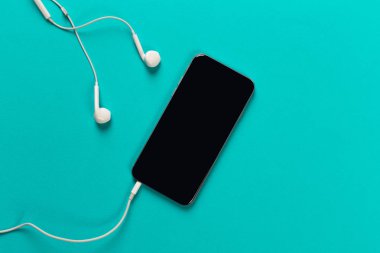 Hareket eden telefon ile renk backgroung, üstten görünüm üzerinde beyaz kulaklık