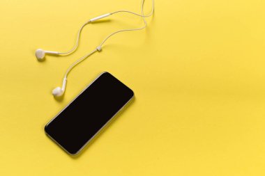 Hareket eden telefon ile renk backgroung, üstten görünüm üzerinde beyaz kulaklık