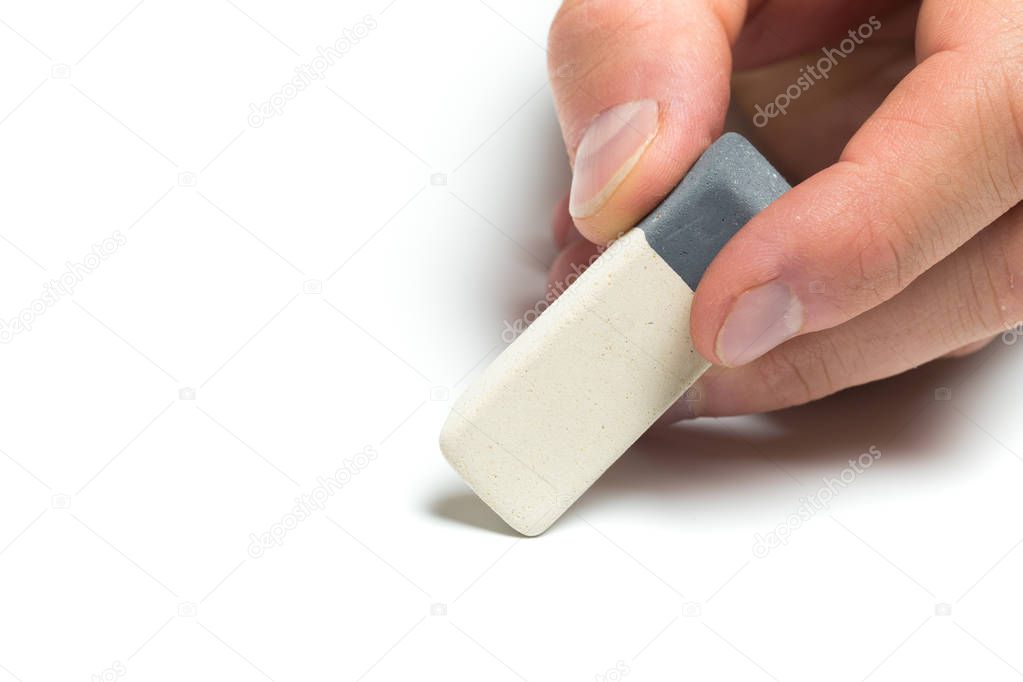 Men's hand holding eraser on isolated backgroung, close up