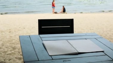 Masanın üzerinde yatan boş bir not defteri sayfaları rüzgar dönüyor