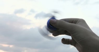 Bir kadın bir kıpır Spinner mavi gökyüzü arka plan üzerinde iplik