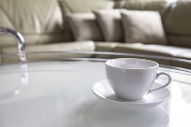 Boş bir beyaz fincan ve bir fincan tabağı sehpa üzerinde durmak