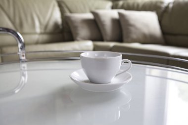 Boş bir beyaz fincan ve bir fincan tabağı sehpa üzerinde durmak