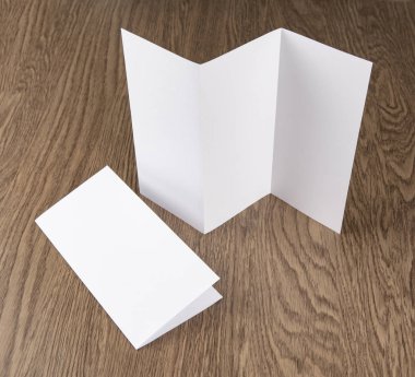 Ahşap arka plan üzerinde beyaz kitapçık mockup.