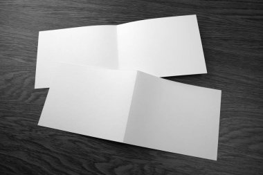 Ahşap arka plan üzerinde beyaz kitapçık mockup.