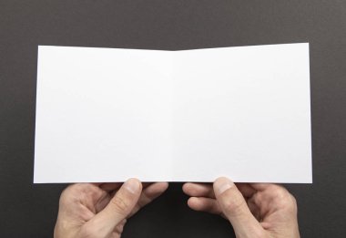 Mens beyaz kitapçık tutan eller