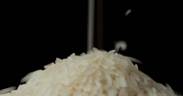 Ρίχνει Κόκκους Λευκό Ρύζι Στο Πιάτο Καθαρό Μαύρο Φόντο — Αρχείο Βίντεο