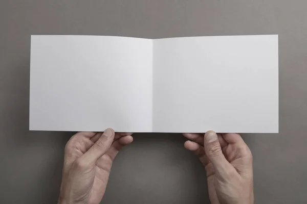 Mens beyaz kitapçık tutan eller — Stok fotoğraf