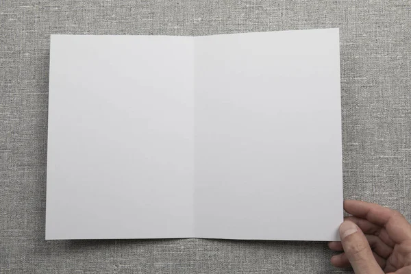 Mens hands holding empty white booklet — Stock Photo, Image