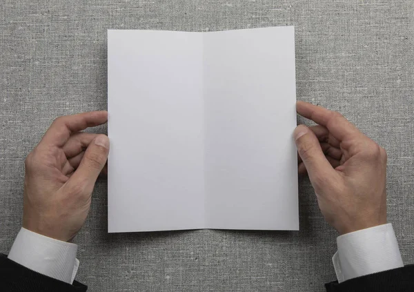 Mens hands holding empty white booklet — Stock Photo, Image