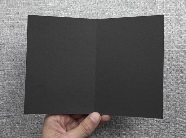 Férfi kezében tartja üres fekete füzet — Stock Fotó