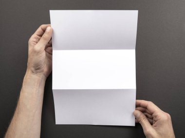 Mens beyaz kitapçık tutan eller