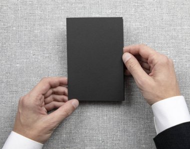 Boş siyah kitapçık holding Mens eller