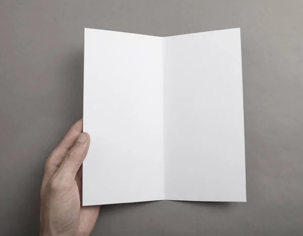 Manos de hombre sosteniendo folleto blanco — Foto de Stock