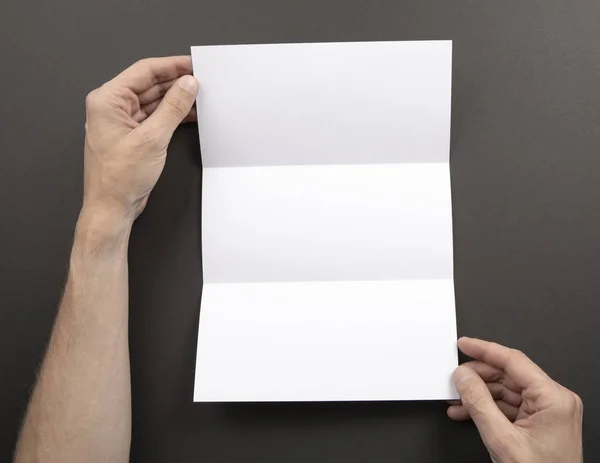 Męskie ręce trzymając biały broszura — Zdjęcie stockowe