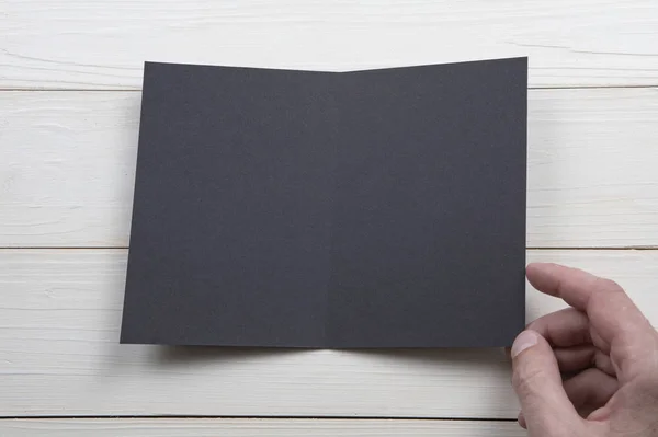 Férfi kezében tartja üres fekete füzet — Stock Fotó