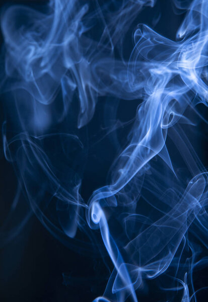 Abstract blue smoke swirls on dark background