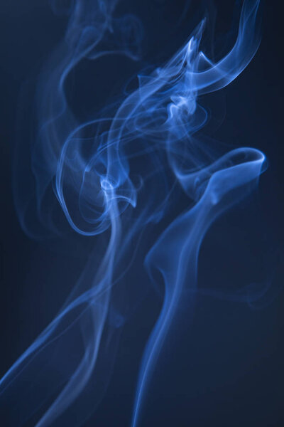 Abstract blue smoke swirls on dark background