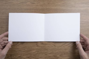 Mens beyaz kitapçık tutan eller