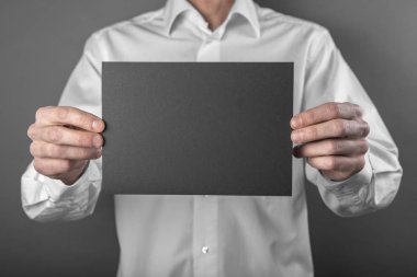 Bir adam tutarak siyah kitapçık