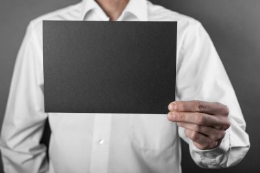 Bir adam tutarak siyah kitapçık