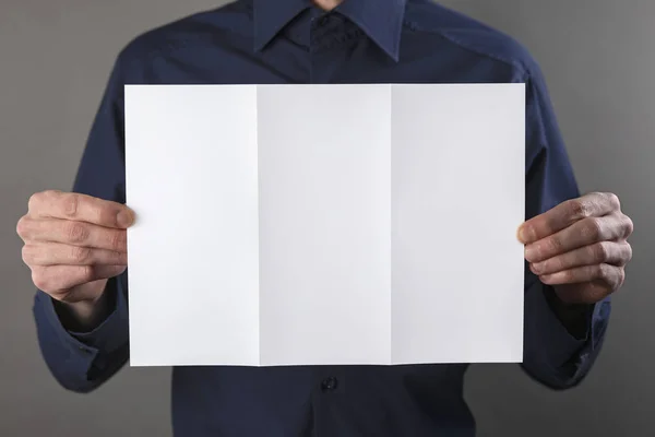 Um homem segurando livreto branco — Fotografia de Stock