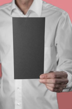 Bir adam tutarak siyah kitapçık