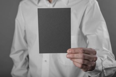 Bir adam tutarak siyah kitapçık