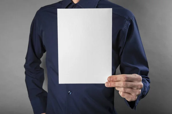 Un hombre sosteniendo un folleto blanco —  Fotos de Stock