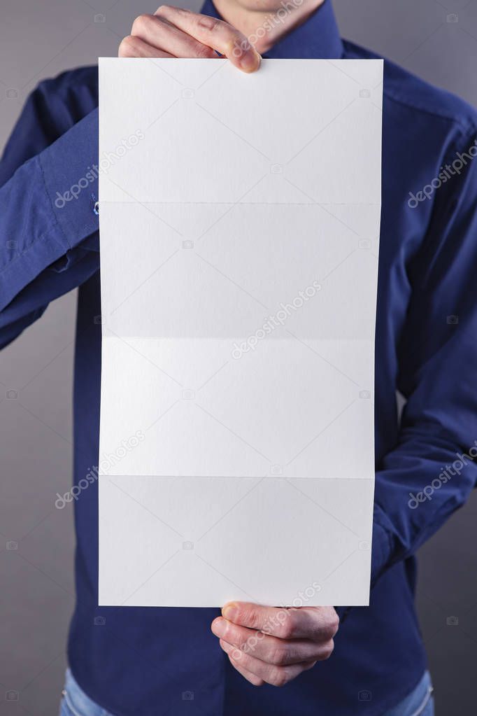 A man holding white booklet