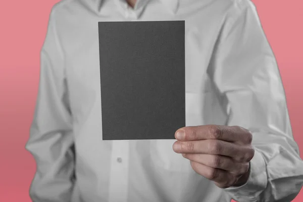 Un hombre sosteniendo un folleto negro — Foto de Stock