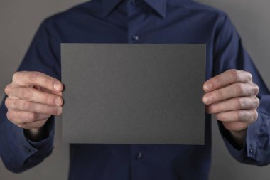 Bir adam tutarak siyah kitapçık