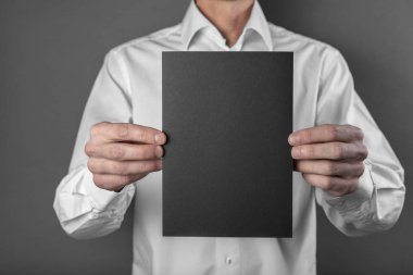 Bir adam tutarak siyah kitapçık