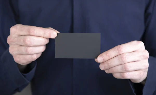 A man holding black business card