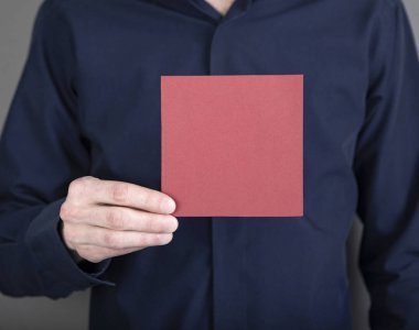 Kırmızı not kağıdı tutan bir adam