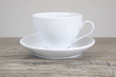 Ahşap masada beyaz kupa ve daire.