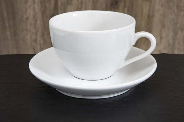 White mug and saucer on a wooden table. — Stock Photo, Image