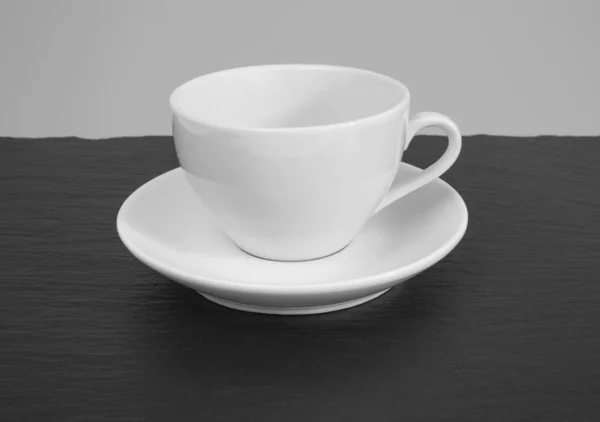 White mug and saucer on a wooden table. — Stock Photo, Image