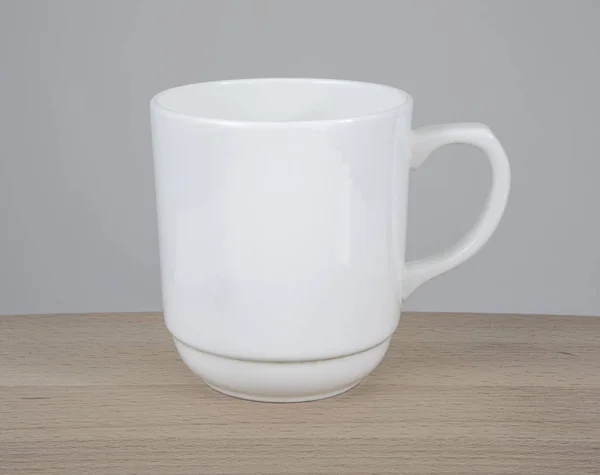 Caneca branca vazia em uma mesa de madeira . — Fotografia de Stock