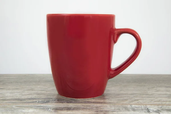 Mug rouge vide sur une table en bois . — Photo