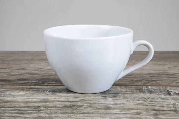 Taza blanca vacía en una mesa de madera . — Foto de Stock