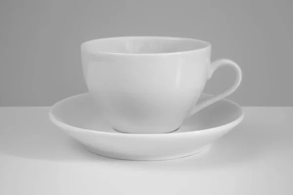 White mug and saucer on a white background. — Stock Photo, Image