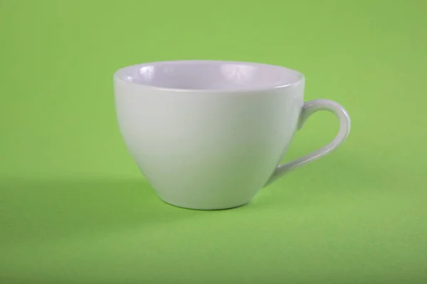 Κενή άσπρη κούπα σε πράσινο φόντο. — Φωτογραφία Αρχείου